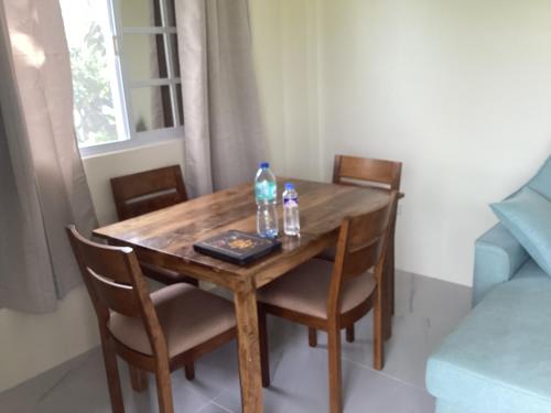 a wooden table with chairs and two bottles on it at Sondol Guesthouse in Loon