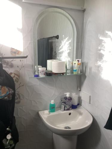 a white bathroom with a sink and a mirror at Sondol Guesthouse in Loon