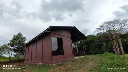 a small house with a black roof on a field at Boca Tapada Inn in Boca Tapada