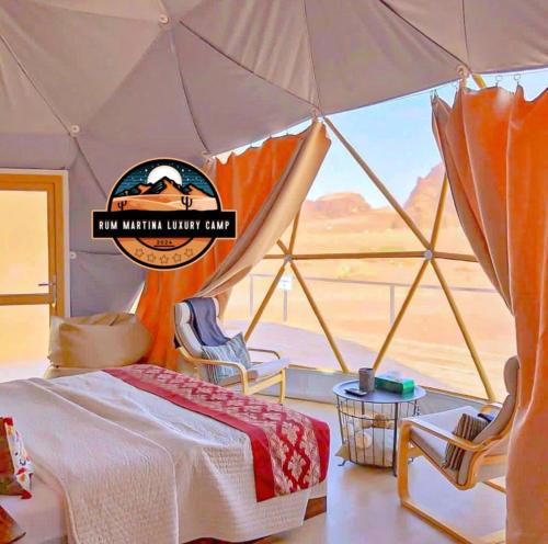 a bedroom with a tent with a view of the desert at RUM MARTINA lUXURY CAMP in Wadi Rum