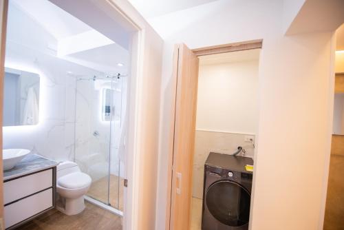 a bathroom with a washer and dryer in it at Apart Suítes Stay Alhambra in Bogotá