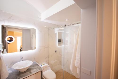 a bathroom with a sink and a glass shower at Apart Suítes Stay Alhambra in Bogotá