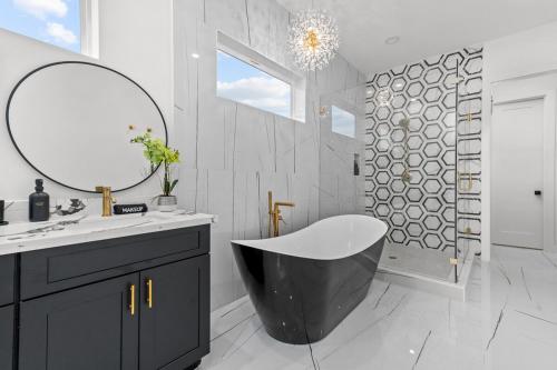 a bathroom with a black and white tub and a mirror at Elegant home with Houston cityscape and rooftop in Houston