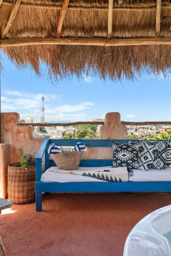 a blue bench sitting under a straw umbrella at Loft Ecochic in Isla Mujeres