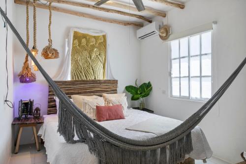 a bedroom with a hammock bed and a window at Loft Ecochic in Isla Mujeres