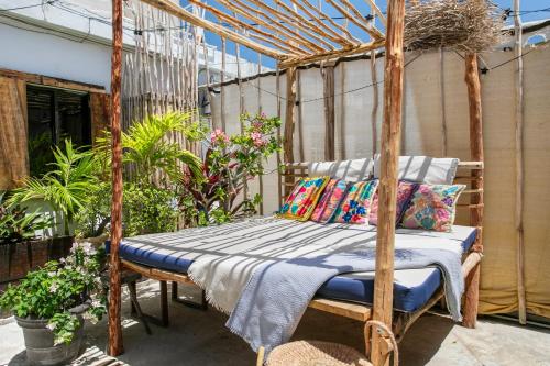 a wooden bed with pillows on a patio at Loft Ecochic in Isla Mujeres