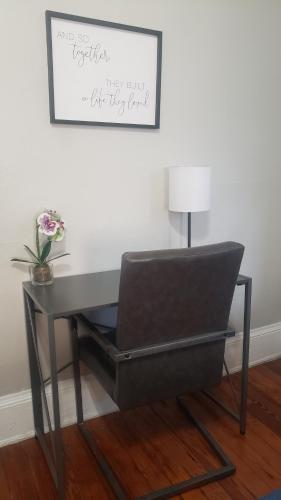 a desk with a chair and a table with a lamp at The Lafayette House in Mobile