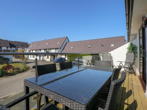 a blue table with chairs on a balcony at Hafan Bach - 233 Cae Du in Abersoch