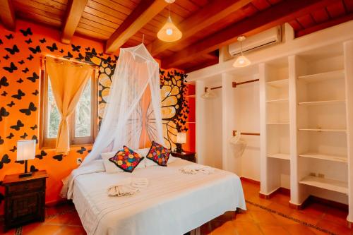 a bedroom with a white bed in a room at Tres Mujeres Hotel in Troncones