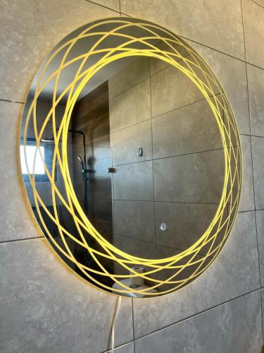 a round mirror with yellow rope on a wall at Luxury Penthouse in Puntacana 2 in Punta Cana