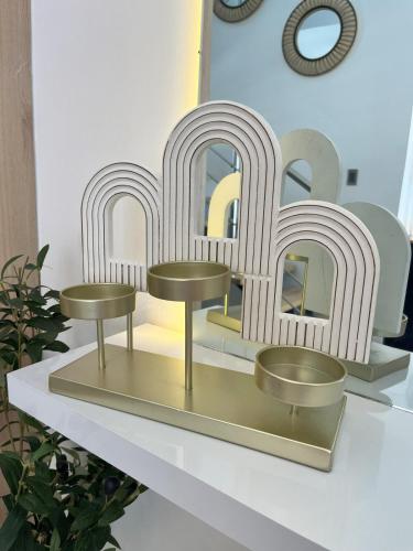 a shelf with two gold stools and a mirror at Luxury Penthouse in Puntacana 2 in Punta Cana
