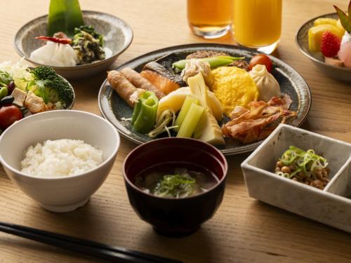 a table with plates of food and bowls of food at Hotel SUI Kyoto Kiyomizu in Kyoto