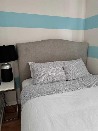 a bedroom with a bed with a blue stripe on the wall at Stylish City Base for Groups and Families, Unit #4 in Halifax