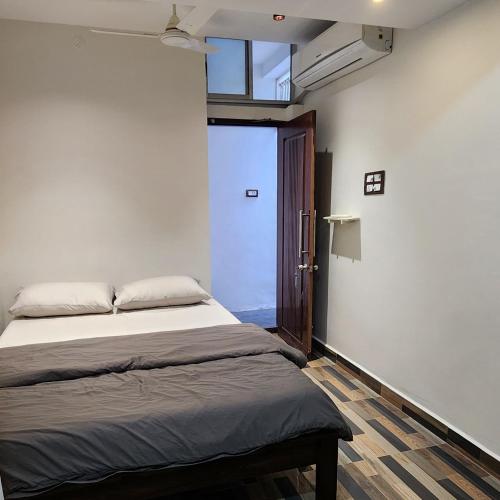 a bedroom with a bed and a window and a door at Stylish comfy Room near Airport in Chennai