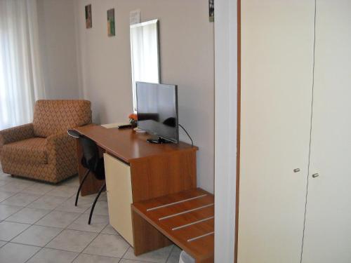 a room with a desk with a television and a chair at Albergo La Posta Arezzo in Badia Al Pino