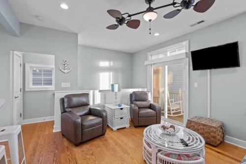 a living room with two chairs and a flat screen tv at Sea Escape townhouse in Atlantic Beach
