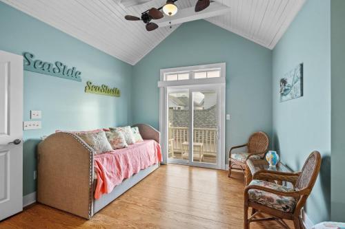 a bedroom with blue walls and a bed and chairs at Sea Escape townhouse in Atlantic Beach