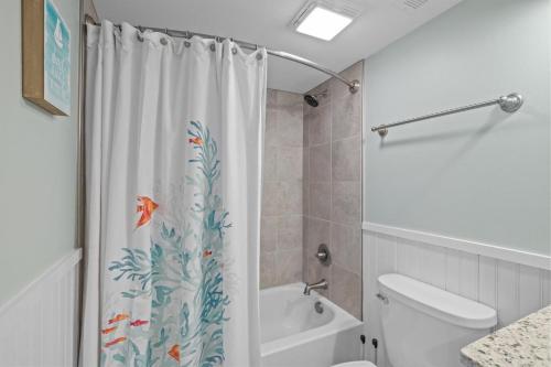a bathroom with a shower curtain with fish on it at Sea Escape townhouse in Atlantic Beach