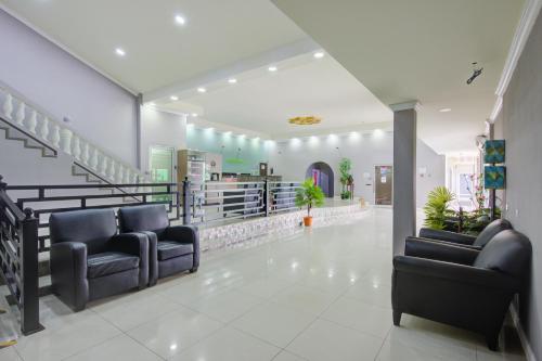 a hospital lobby with two chairs and stairs at Airport Suites Hotel in Piarco