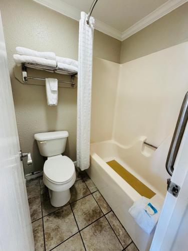 a bathroom with a toilet and a bath tub at Oak Grove Inn in Branson