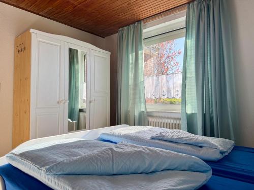a bedroom with two beds and a window at Bensersiel Ferienwohnung Kapitän mit Terrasse und Garten in Bensersiel