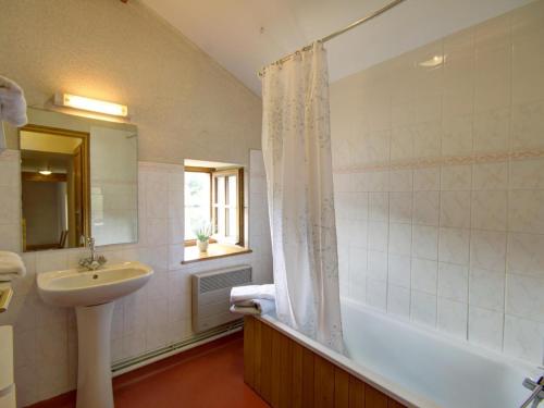 a bathroom with a sink and a bath tub and a sink at Gîte au calme avec terrasse, cheminée et pêche à proximité, animaux acceptés. - FR-1-496-225 in Les Salles
