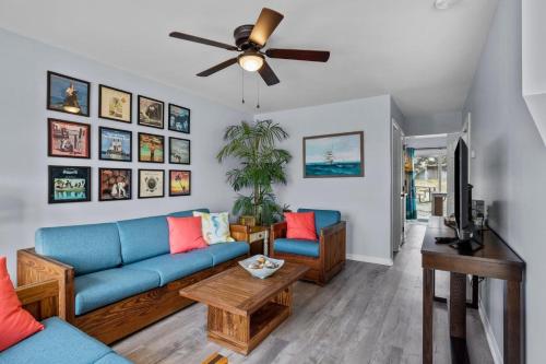 a living room with a blue couch and a ceiling fan at Anchors Away Unit 4 Duplex in Atlantic Beach