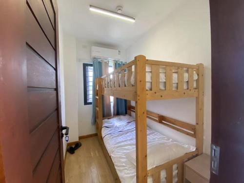 two bunk beds in a small room with a door at XKH（NINE STAR）APARTMENT in Dumaguete
