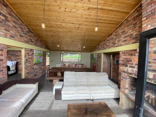 a living room with white couches and a brick wall at Casa Quinta Mozart in Guatavita