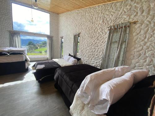 a bedroom with two beds and a couch and a window at Casa Quinta Mozart in Guatavita