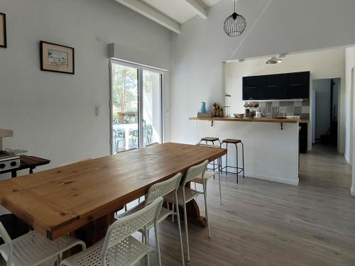 une cuisine et une salle à manger avec une table et des chaises en bois dans l'établissement Charmante Villa Rénovée avec Jardin, Climatisée, Pour 8 Pers - Quartier Boisé à La Palmyre - FR-1-705-52, aux Mathes
