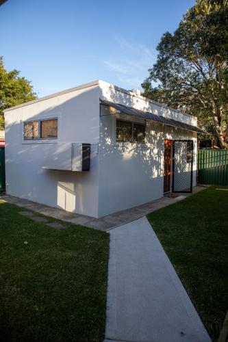 a white house with a pathway in front of a yard at Relaxing Guest Home Near Airport in Sydney