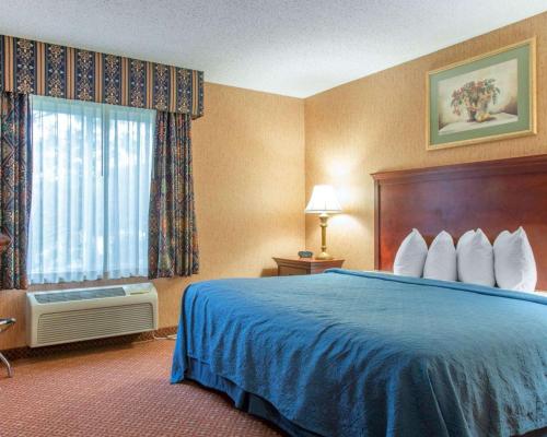 a hotel room with a bed and a window at Quality Inn & Suites in Meriden