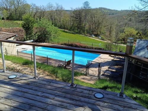 - une vue sur la piscine depuis la terrasse dans l'établissement Chalet rustique avec terrasse et WiFi au cœur du Périgord Noir - FR-1-616-387, à Saint-Pompont