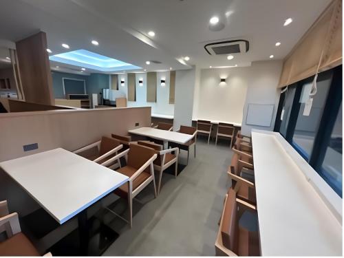 an empty restaurant with tables and chairs at Smile Hotel Namba in Osaka