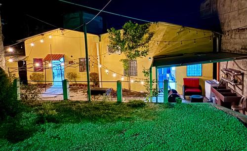 a house with lights in the yard at night at Hostal Inn 1 in Flores