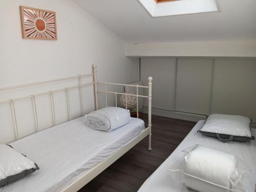 - une chambre avec 2 lits et une horloge murale dans l'établissement Villa Moderne entre Forêt et Océan à Seignosse - FR-1-239-1112, à Seignosse