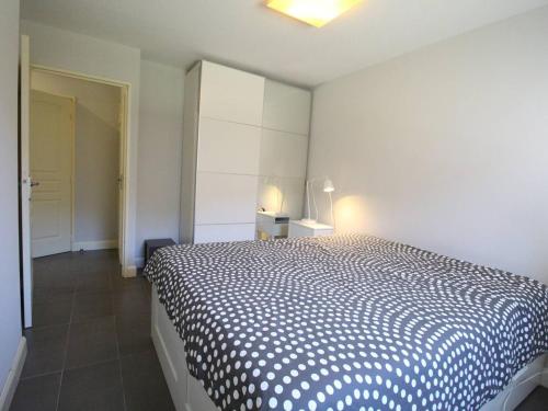 une chambre avec un lit avec une couette noire et blanche dans l'établissement Appartement moderne 51m² à Luchon - 4 pers, Terrasse, Parking - FR-1-313-241, à Luchon