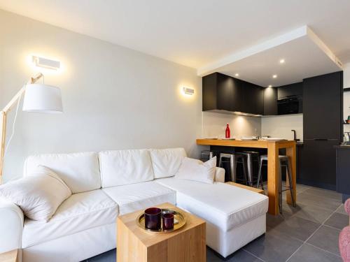 un salon avec un canapé blanc et une cuisine dans l'établissement Duplex rénové 6 pers avec vue sur lac à Loudenvielle - FR-1-695-72, à Loudenvielle