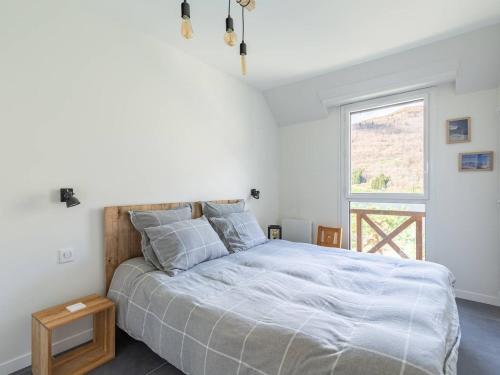 una camera da letto con un letto grande e una finestra di Duplex rénové 6 pers avec vue sur lac à Loudenvielle - FR-1-695-72 a Loudenvielle
