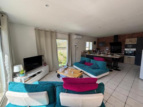 un salon avec des canapés bleus et une cuisine dans l'établissement Maison climatisée à Biscarrosse Bourg, 5 pers, ménage inclus - FR-1-319-596, à Biscarrosse