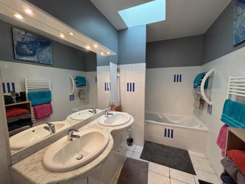 La salle de bains est pourvue de 3 lavabos et d'une baignoire. dans l'établissement Maison climatisée à Biscarrosse Bourg, 5 pers, ménage inclus - FR-1-319-596, à Biscarrosse