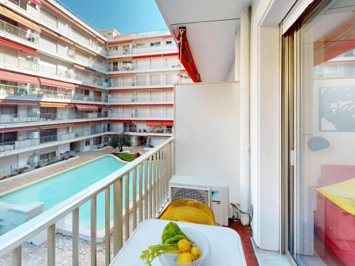 - un balcon avec vue sur un bâtiment doté d'une piscine dans l'établissement Studio climatisé avec terrasse et wifi proche plages à Menton - FR-1-196-377, à Menton