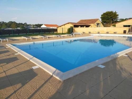 une grande piscine avec de l'eau bleue dans l'établissement Mobil-home confortable proche de l'Atlantique - FR-1-426-577, à Saint-Hilaire-de-Talmont