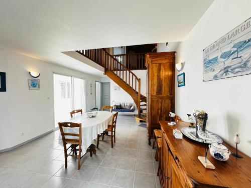 une salle à manger avec une table et des chaises et un escalier dans l'établissement Maison de ville à Fouras, 4 pers, proche plage et centre - FR-1-709-95, à Fouras