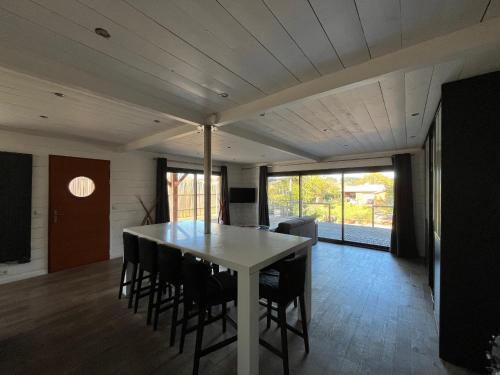 une salle à manger avec une table et des chaises blanches dans l'établissement Belle maison de 4 chambres au bord du canal à Cazaux - FR-1-319-598, à La Teste-de-Buch