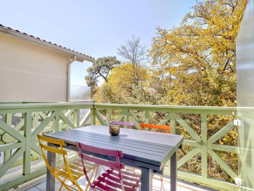 une table en bois et deux chaises sur un balcon dans l'établissement Arcachon: Appart T2 Résidentiel Près Plage, 2 Balcons - FR-1-433-137, à Arcachon