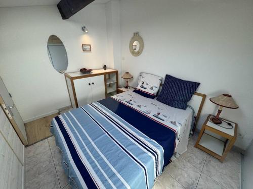 une petite chambre avec un lit et un miroir dans l'établissement Pavillon Cap d'Agde T2 Mezzanine 4 Pers avec Terrasse - FR-1-749-96, au Cap d'Agde