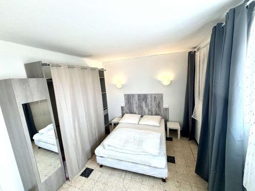 une petite chambre avec un lit et un miroir dans l'établissement Appartement 2 Pièces, Terrasse Vue Mer, Parking Privé - FR-1-229C-108, à Port-la-Nouvelle