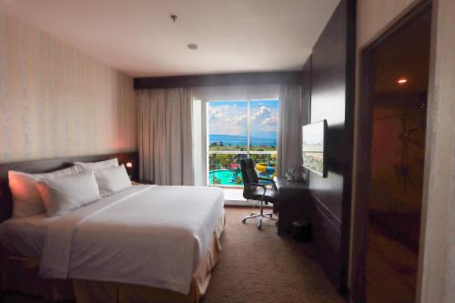 a hotel room with a bed and a window at Labersa Hotel & Convention Center Toba Balige in Balige